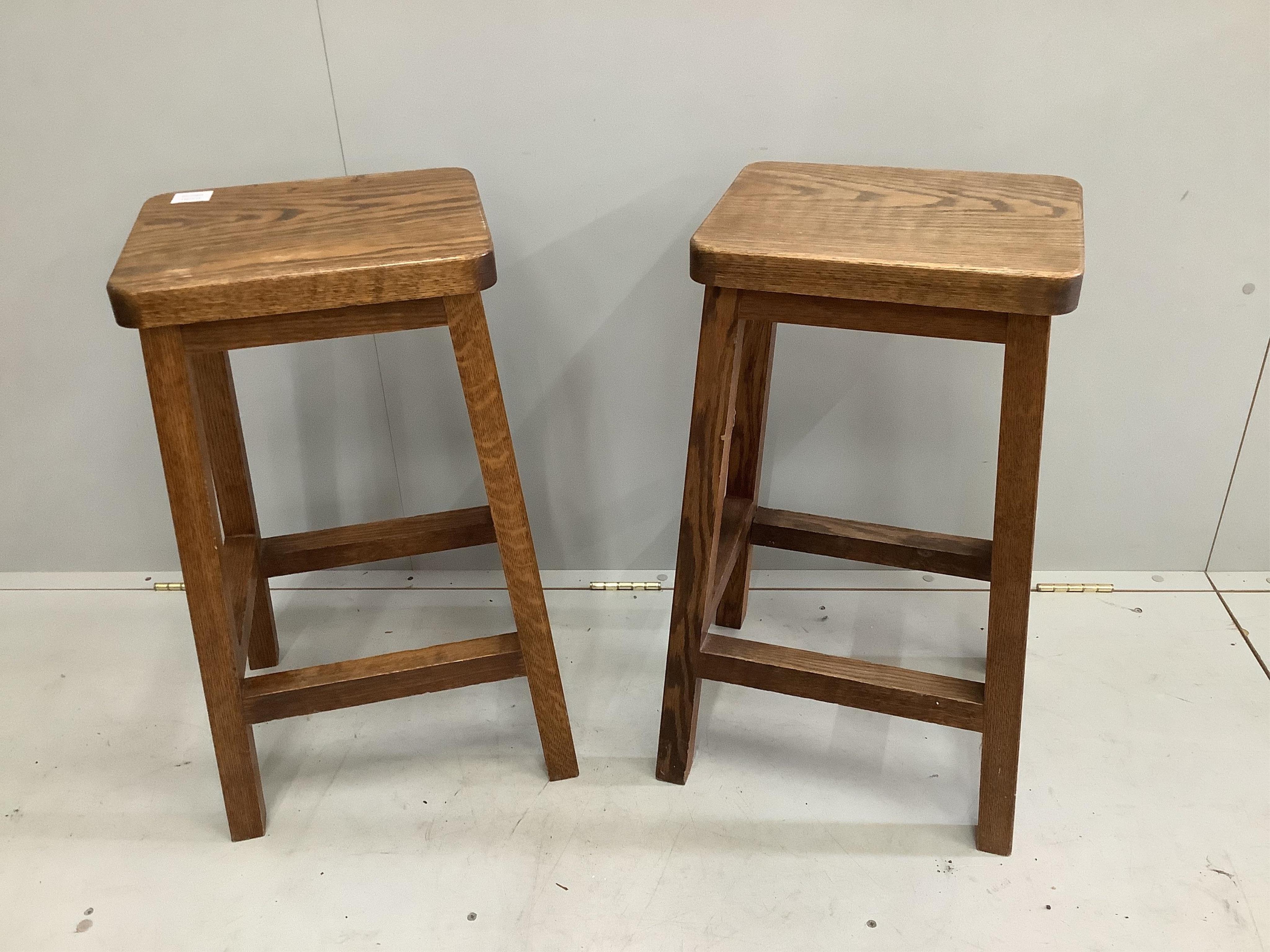 A pair of mid century oak stools, width 35cm, depth 28cm, height 69cm. Condition - fair